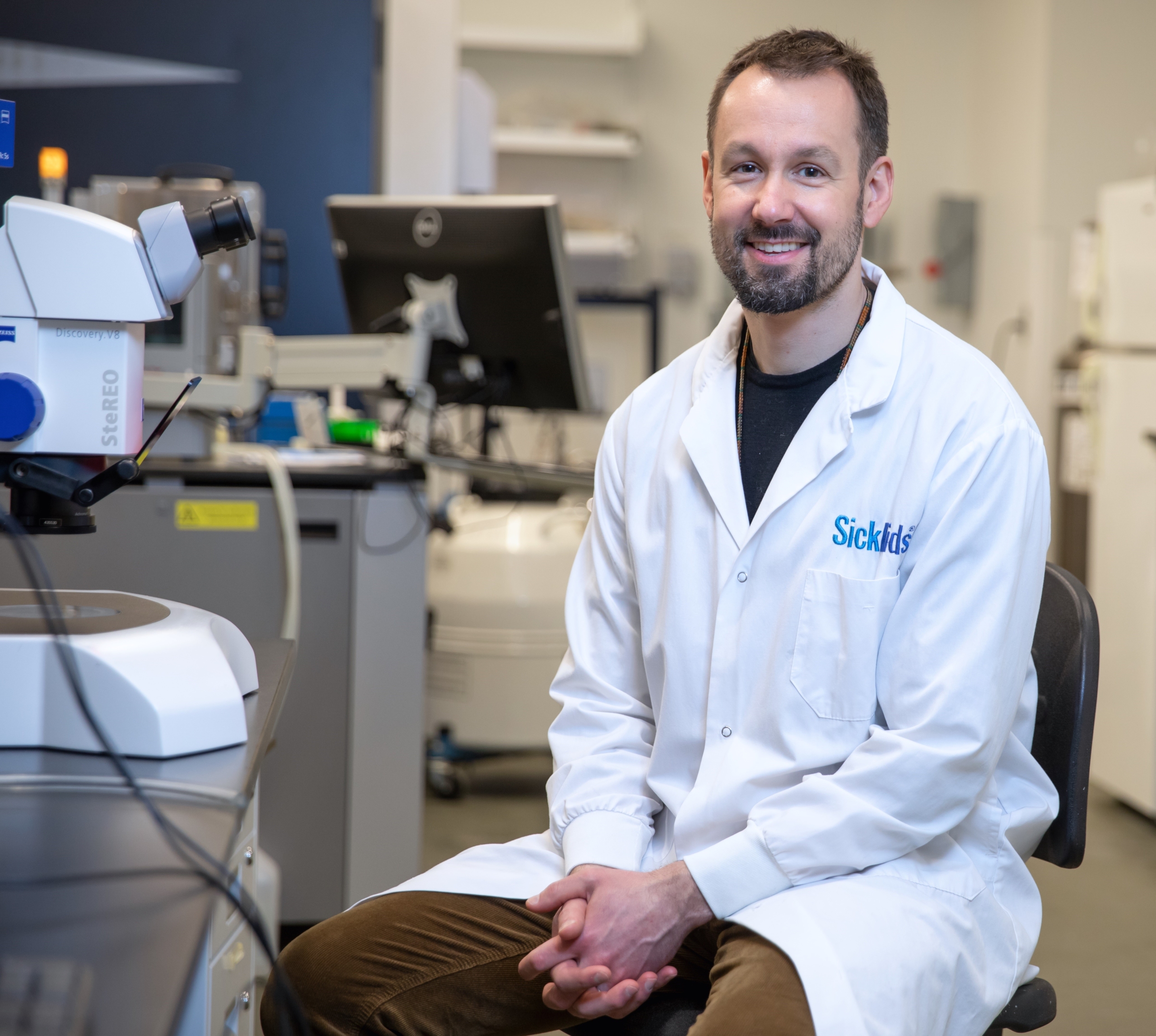 Dr. Jean-Philippe Julien sits in his laboratory wearing a SickKids lab coat.